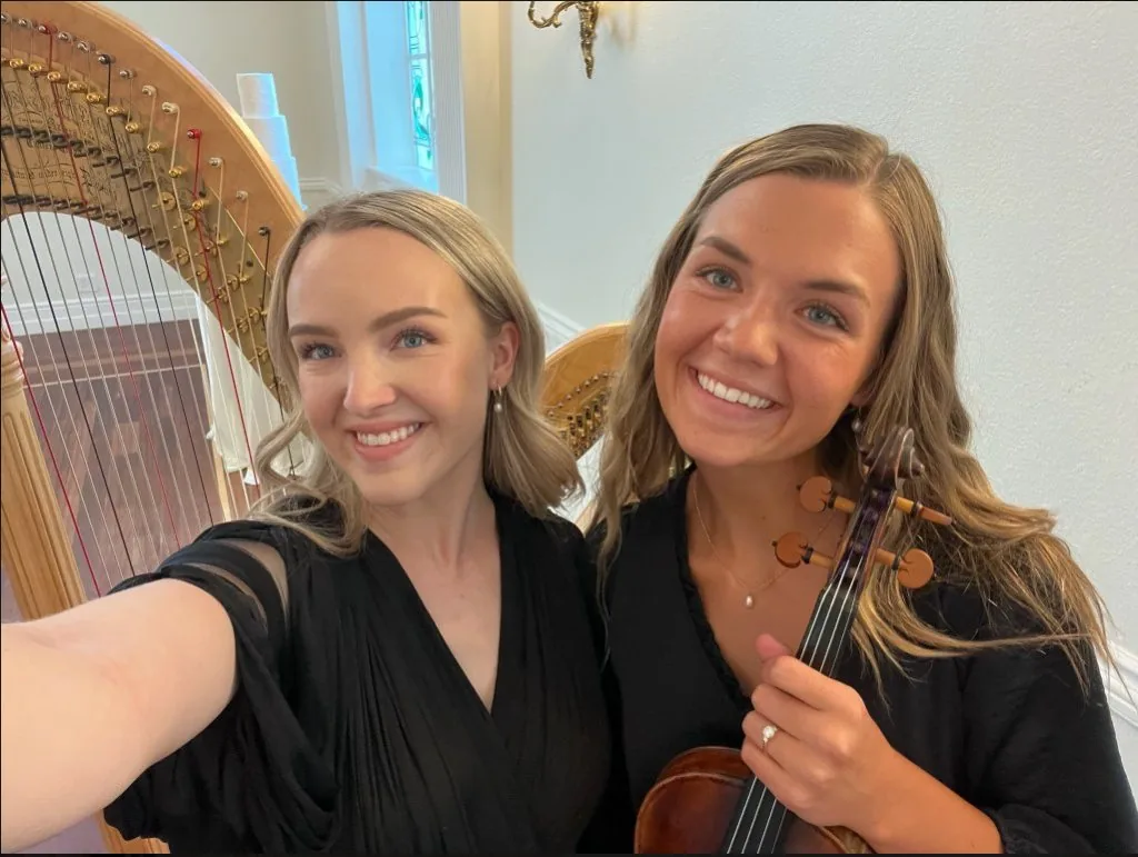 Monet and Eliza smiling together with harp and violin