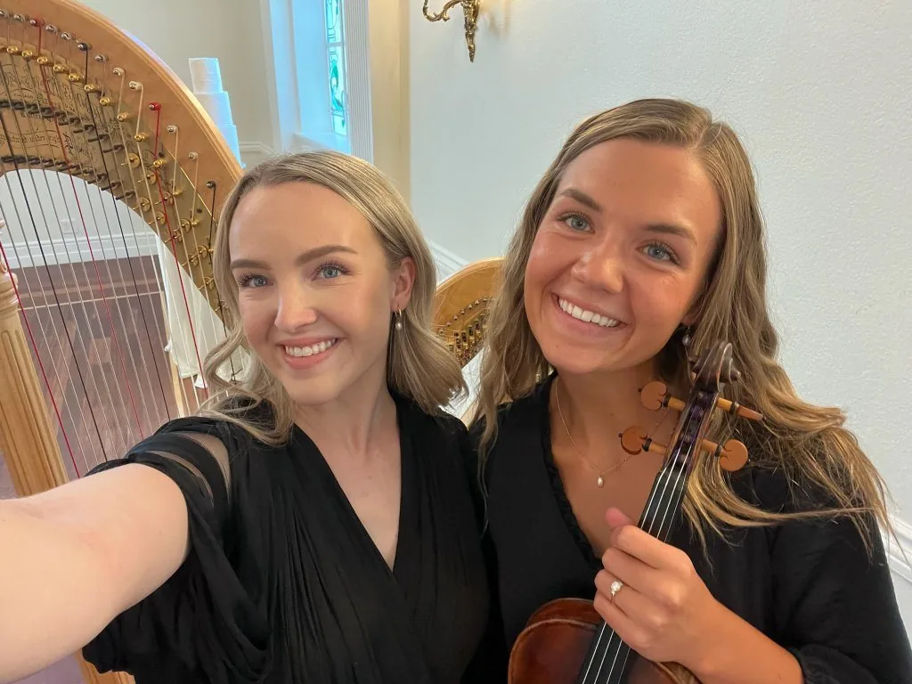 Monet and Eliza smiling together with harp and violin