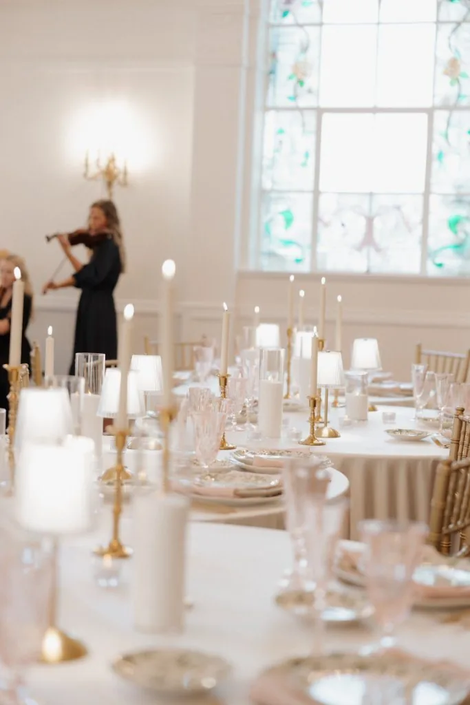 Candlelit reception table with the duo in the background