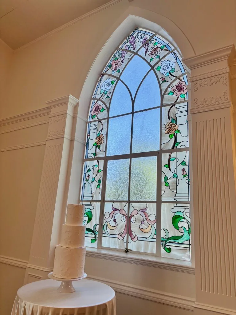 Wedding cake in front of a stained glass window